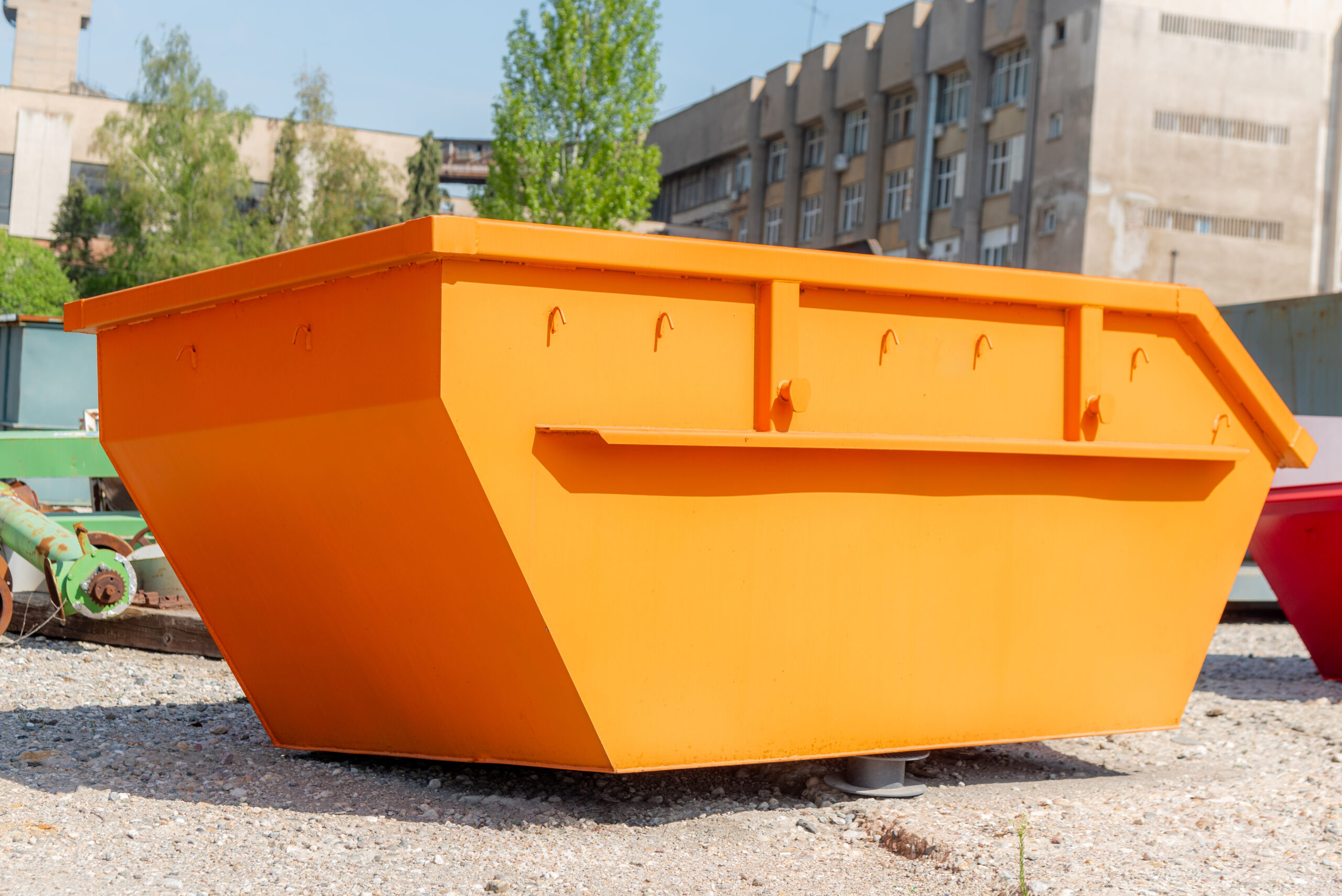 Orange construction-waste skip container in a yard