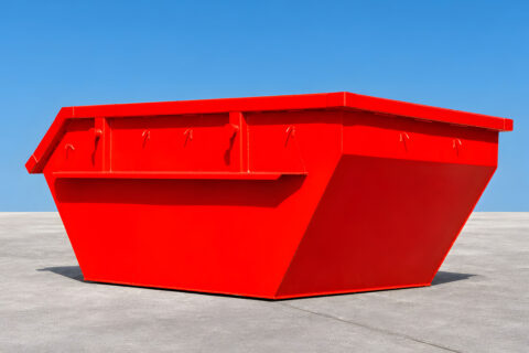 Red construction-waste skip container on a grey floor