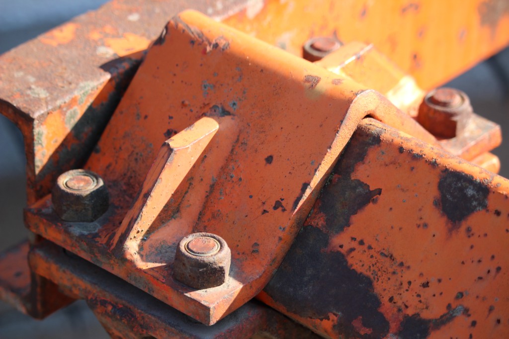 Weathered bolted metal plate connection with peeling paint