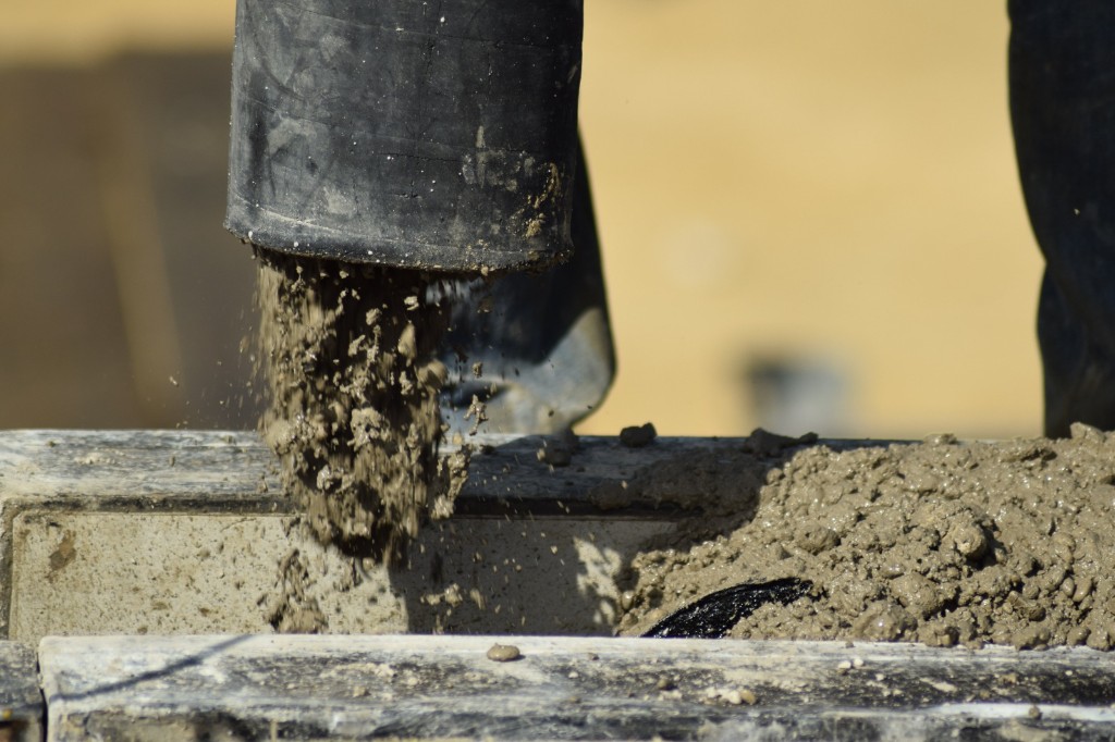 Wet concrete pouring from a pump hose into formwork